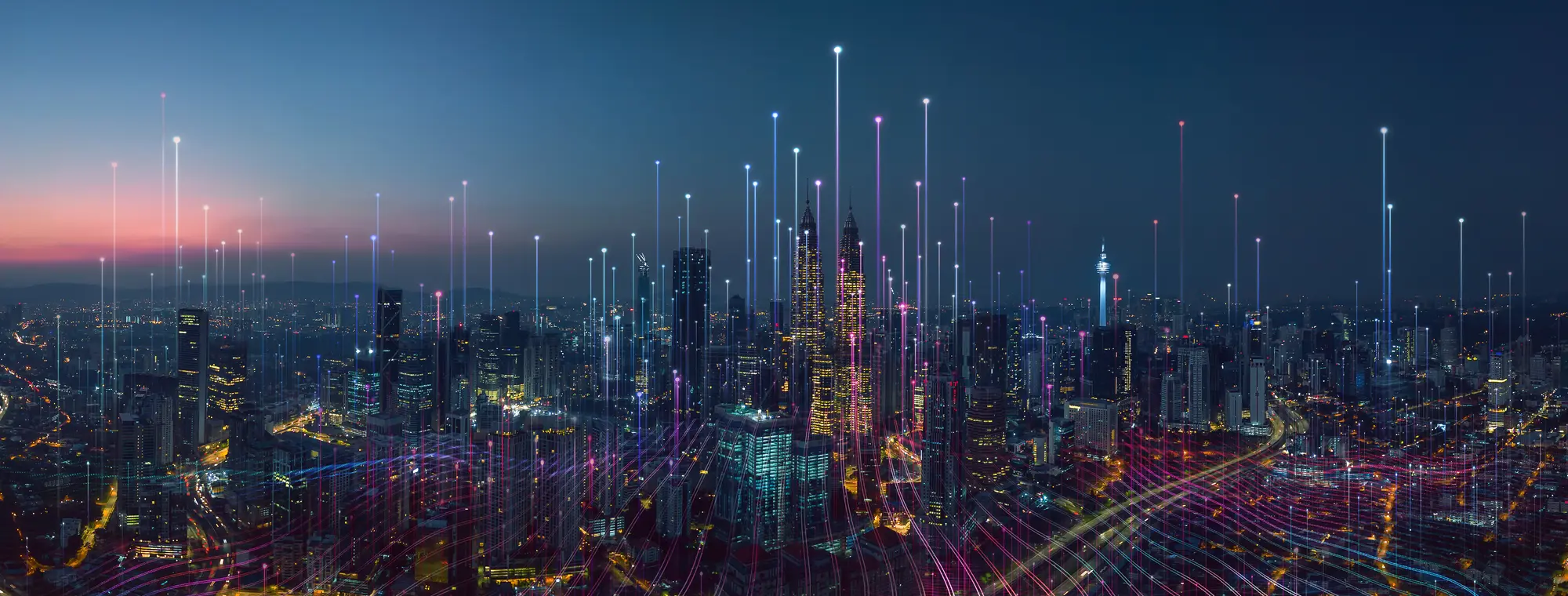 A connected city skyline at dusk with data signals rising from the buildings
